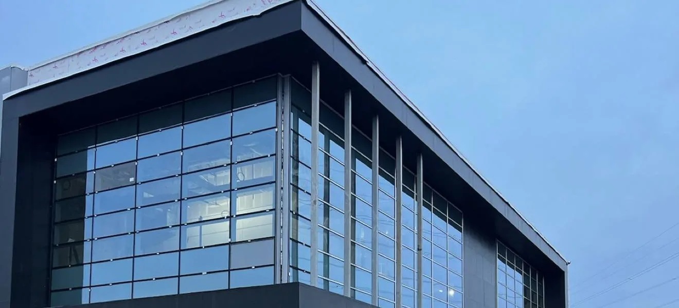 Fachada de vidrio de un edificio comercial en obra, vista amplia de día